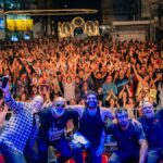 Palco montado na orla de Guarapari durante o Festival de Inverno com público e estrutura de evento cultural.